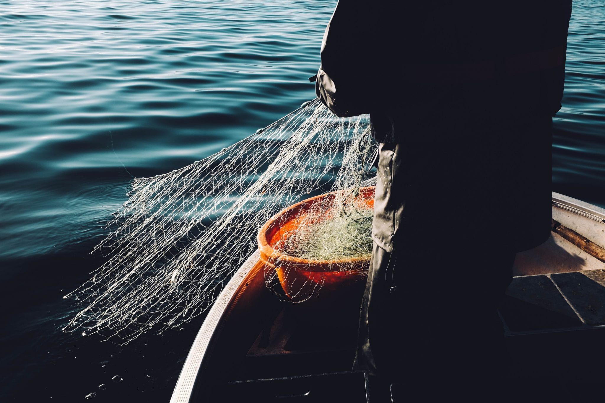 man fishing off boat in the ocean